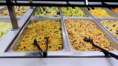 Markette, raflardaki tepsilerde düzgünce sergilenecek çeşit çeşit yemekler. Kapatın. Yüksek kalite 4k görüntü