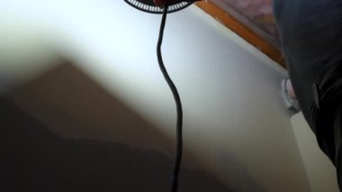 İnşaat işçisi zımpara kağıdıyla sıvanmış bir duvarı zımparalıyor. İşçi koruyucu eldiven takıyor ve boyama işi için duvarı düzleştiriyor. Yüksek kalite 4k görüntü