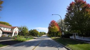 Sunny Autumn Mahallesi 'nde küçük bir kasaba sokağında araba sürerken görüntüsü. Yüksek kalite 4k görüntü