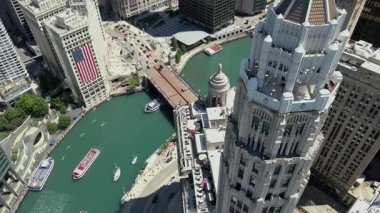 Burası Chicago şehir merkezi, Kulüp Quarters Binası Mather Kulesi, Wrigley Binası ABD bayrağı ve Chicago Nehri ile turist gemilerini gösteriyor. USA IL Chicago 20 Haziran 2025. Yüksek kalite 4k görüntü