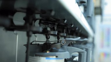 Endüstriyel boya karıştırma makinesinin yakın görüntüsü. Mekanik kollar ve hortumlar bir kabın içine boya karıştırarak otomatik karıştırma işlemini gösteriyor. Yüksek kalite 4k görüntü