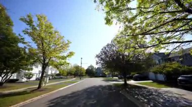 Sunny Autumn Mahallesi 'nde küçük bir kasaba sokağında araba sürerken görüntüsü. Yüksek kalite 4k görüntü