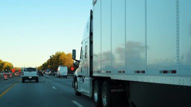 Açık bir sonbahar gününde yarı kamyon eyaletler arası yoğun bir otoyolda kargo taşır. Karavan sürekli trafikte, uzun mesafeli taşımacılık, lojistik ve tedarik zinciri operasyonlarında hareket ediyor. Yüksek kalite 4k görüntü