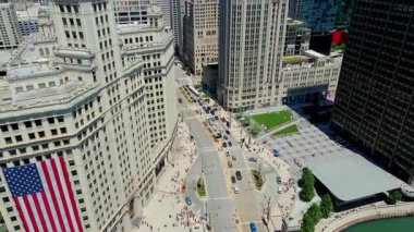 Burası Chicago şehir merkezi, Wrigley Binası 'nda büyük ABD bayrağı ve caddelerde trafik var. USA IL Chicago 20 Haziran 2025. Yüksek kalite 4k görüntü