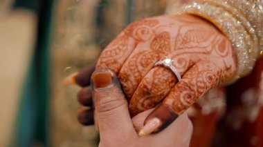 Damat, nişan yüzüğüyle boyanmış bir gelin kınası tutuyor. Geleneksel Hint kıyafetleri, Hint düğünü unsurları. - Evet. Yüksek kalite 4k görüntü