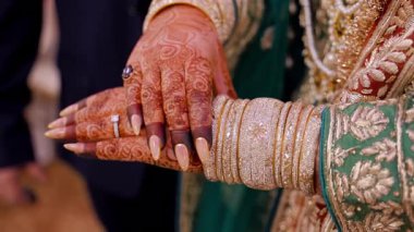 Geleneksel Hint ya da Pakistan kınasına yakından bakın. Nikah yüzükleriyle gelin elleri boyanmış. Gelin ellerindeki bilezikleri inceliyor. Yüksek kalite 4k görüntü