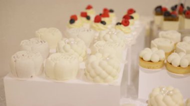 Masa köpüklü kekler, mini pastalar. Güzel dokuların sunumu, kremalı malzemeler ve düğünler, kutlamalar, lüks yemek organizasyonları için ince detaylar. Yüksek kalite 4k görüntü