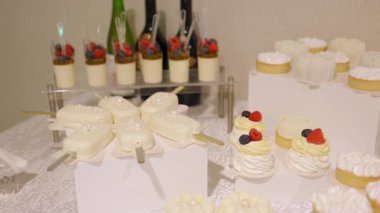 Masa köpüklü kekler, bardakta tatlı, mini pastalar. Güzel dokular, kremalı malzemeler, düğünler, kutlamalar, lüks yemek organizasyonları için ince detaylar. Yüksek kalite 4k görüntü