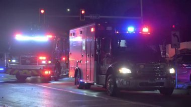 Gece vakti yol kenarındaki bir olayda çalışan acil durum araçları. Polis arabaları, itfaiye araçları, ambulanslar, kırmızı ışıkta duran arabalar. USA IL Naperville 14 Aralık 2025. Yüksek kalite 4k görüntü