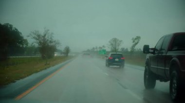 Yağmurlu otoyol boyunca giden içeriden bir araç. Cam silecekleri sisli, bulutlu hava görüşü azalttığı için camda hareket ediyor. ABD KY Park Şehri 15 Kasım 2025. Yüksek kalite 4k görüntü