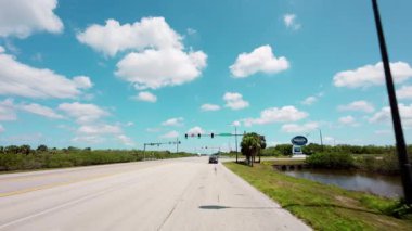 POV açık gökyüzü olan güneşli bir günde Kennedy Uzay Merkezi Ziyaretçi Kompleksi 'ne doğru gidiyor. Uzay Merkezi işareti. USA IL Miami 01 Nisan 2025. Yüksek kalite 4k görüntü