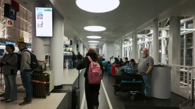 Kalabalık havaalanı terminali. Koridorda yürüyen gezginler, bavullar ve sırt çantaları taşıyorlar. Modern iç mekan, yoğun seyahat ortamı. ABD Şikago IL 26 Aralık 2025. Yüksek kalite 4k görüntü