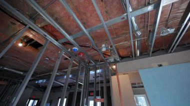 Tamamlanmamış iç tavan, havalandırma kanalları, borular ve metal çerçeve açıkta. İnşaat veya yenileme sırasında mekanik sistem kurulumu. Yüksek kalite 4k görüntü