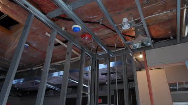 Tamamlanmamış iç tavan, havalandırma kanalları, borular ve metal çerçeve açıkta. İnşaat veya yenileme sırasında mekanik sistem kurulumu. Yüksek kalite 4k görüntü