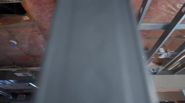 Yarım kalmış bir tavana yerleştirilmiş havalandırma sisteminin POV 'u. Metal çerçeve, hava kanalları ve yalıtımlı. Bina inşaatı veya tadilatı. Yüksek kalite 4k görüntü