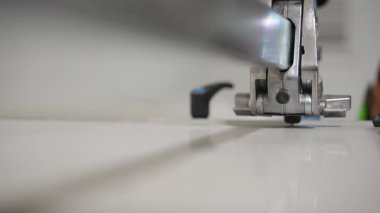 Fayans yüzeyini kesen elektrikli bir fayans kesme makinesinin yakın çekimi. Hassas kesim, profesyonel yenileme çalışmaları ve doğru malzeme hazırlığı. Yüksek kalite 4k görüntü