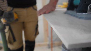 Bir inşaat işçisinin POV 'u zımpara makinesi kullandıktan sonra kumlu duvar yüzeyini eliyle kontrol ediyor. Kalite kontrol, yüzey hazırlığı, profesyonel yenileme işleri. Yüksek kalite 4k görüntü