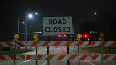 Gece yol tabelasında yanan inşaat bariyerleri vardı. Trafik kontrolü, yol bakımı, kamu güvenliği altyapısı, gece inşaatı. POV görünümü. Yüksek kalite 4k görüntü