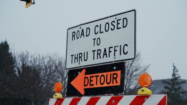 Karla kaplı bir caddede servis yolu uyarısı olan kapalı bir yol tabelası duruyor. Trafik kontrolü, yol güvenliği, kar yağışı nedeniyle ulaşım kesintisi. POV görüntüsünü kapat. Yüksek kalite 4k görüntü