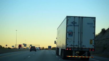 ABD, Halls TN, 14 Novem 2025 Güz Akşam Otobanı 'nda römorklu tırın yanında köprünün altından geçiyor. Geniş çaplı. Ulaşım, lojistik, nakliye. Yüksek kalite 4k görüntü