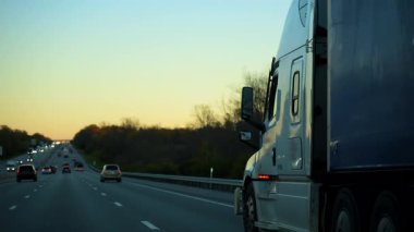 Sonbahar akşamı otobanı üzerinde çadır römorku olan kamyonun yanına gidiyorum. Geniş açılı geniş açı. Ulaşım, lojistik, kargo teslimatı ve ticari seyahat. Yüksek kalite 4k görüntü