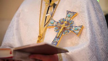 Süslü bir haç ve ayinsel kıyafetlerin yer aldığı Ortodoks Hıristiyan rahip cüppesinin yakın çekimi. Dini tören bağlamında. - Evet. Yüksek kalite 4k görüntü