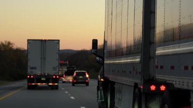 Sonbahar akşamı otobanında kamyonlara yakın sürüyorum. Geniş açılı geniş açı. Ulaşım, lojistik, kargo teslimatı ve ticari seyahat. Yüksek kalite 4k görüntü