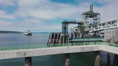 Feribot liman suyu, deniz taşımacılığı altyapısı, gündüz vakti sahil sahili üzerinde çelik yükleme yapısıyla sanayi limanına yaklaşıyor. Yüksek kalite 4k görüntü