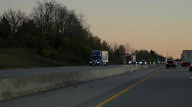 Gün batımında kargo karavanı taşıyan mavi SWFT kamyonu taşraya naklediliyor. Ulaşım, lojistik, teslimat. ABD Knoxville, TN 2 Kasım 2025. Yüksek kalite 4k görüntü