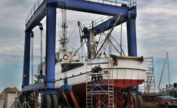 Arbeiter reparieren ein Fischerboot Stockbild