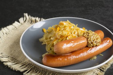 Domuz pastırmalı sosis ve lahana turşusu.