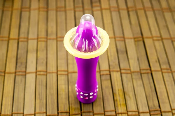 vibratör ve prezervatif ahşap arka plan üzerinde