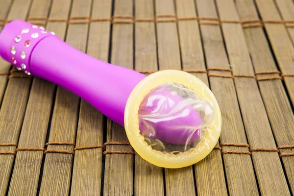 vibratör ve prezervatif ahşap arka plan üzerinde