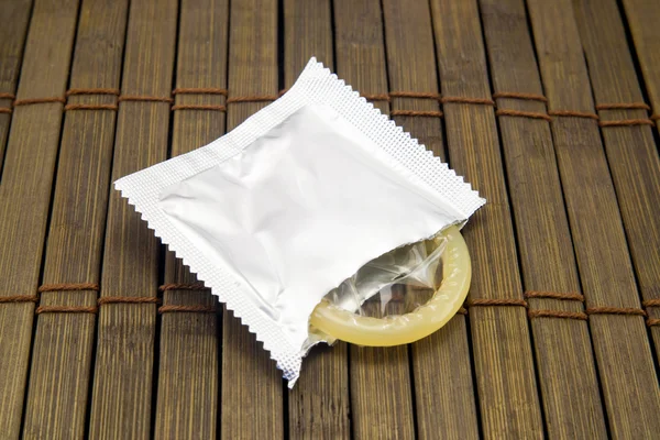 Jedną prezerwatywę na drewniane tła — Zdjęcie stockowe