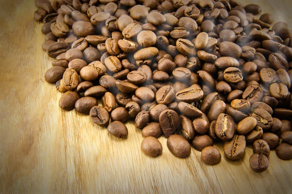 Granos de café sobre tabla de madera vintage —  Fotos de Stock