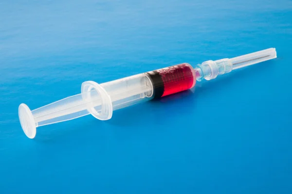 Syringe with red liquid — Stock Photo, Image