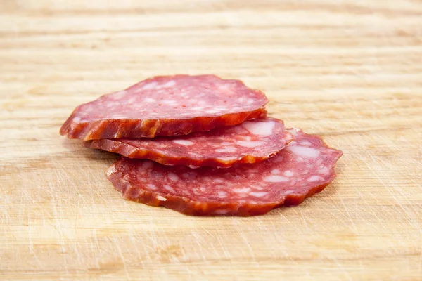 Salsicce di salame isolate su tavola di legno — Foto Stock