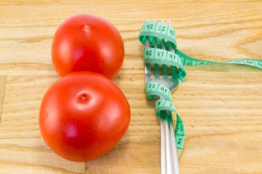 Ölçüm bandı ve bir çatal ile domates izole 