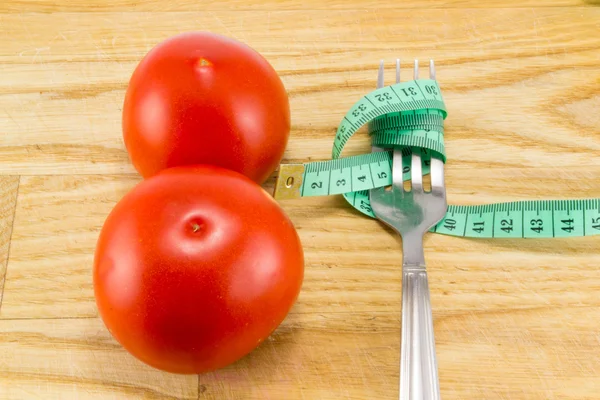 Nastro di misura e una forchetta con pomodoro isolato — Foto Stock