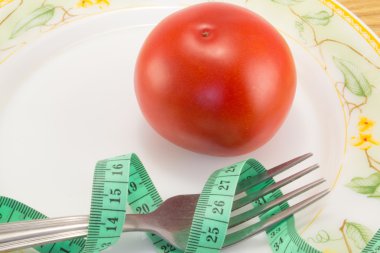 Ölçüm bandı ve bir çatal ile domates izole 