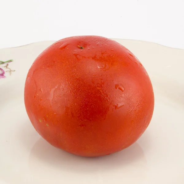 Tomato on a white plate — Stock Photo, Image