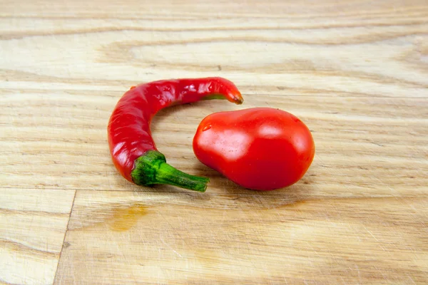 Pimentas vermelhas na tábua de cortar — Fotografia de Stock