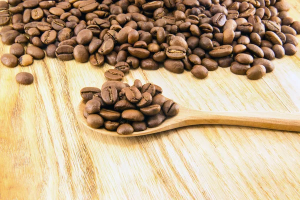 Coffee beans on vintage wooden board — Stock Photo, Image