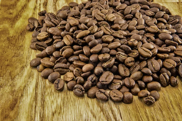 Granos de café sobre tabla de madera vintage —  Fotos de Stock