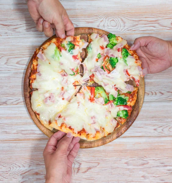 Friends hands taking slices of pizza