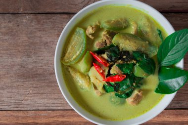 Tay tavuk yeşil köri ile eski ahşap arka plan