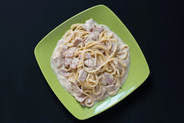 Spaghetti Carbonara med bacon och ost, ovanifrån på svart bac — Stockfoto