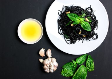 Zeytinyağı ve sarımsak siyah arka plan üzerine siyah spagetti