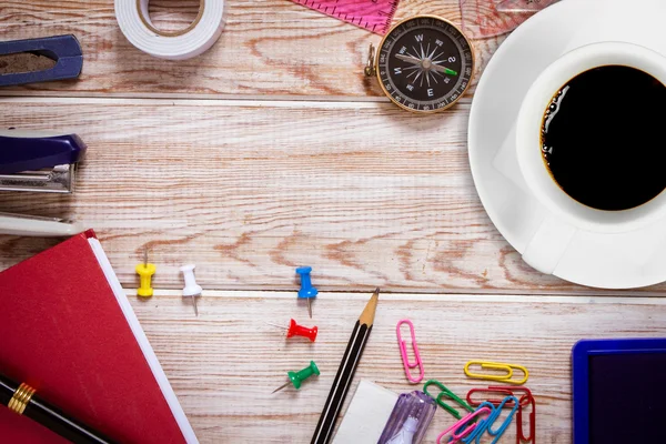 Top view of white coffee cup with office supplies on wood table — Stock Photo, Image