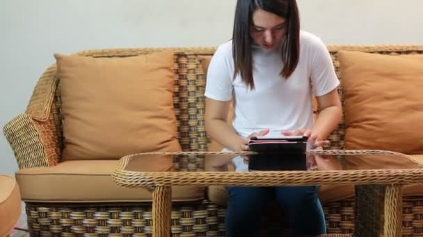 HD Dolly meisje genieten met haar tablet in woonkamer — Stockvideo